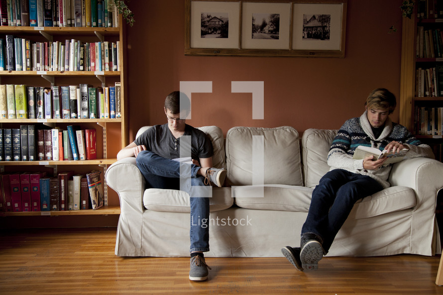 men sitting on a couch in a library reading a Bible 