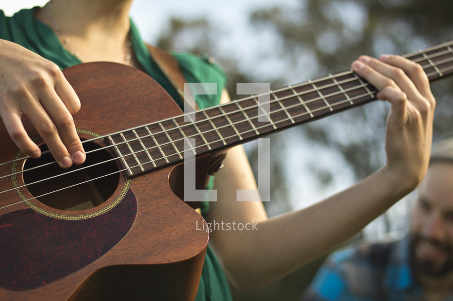 torso of a woman playing a guitar 