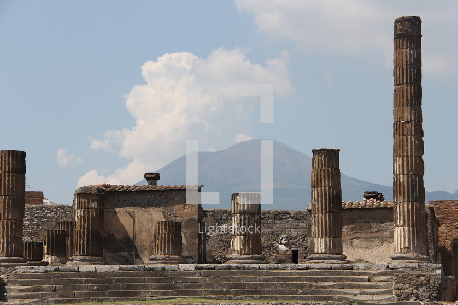 Roman columns in a ruins with Mt Vesuvius in the background 