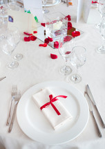 Table set for a Wedding reception with red decorations.