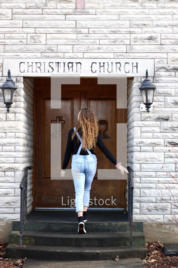 a young woman entering a church 
