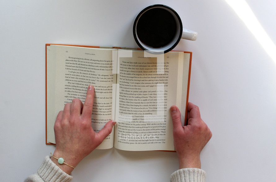 woman reading a book with a mug of coffee 