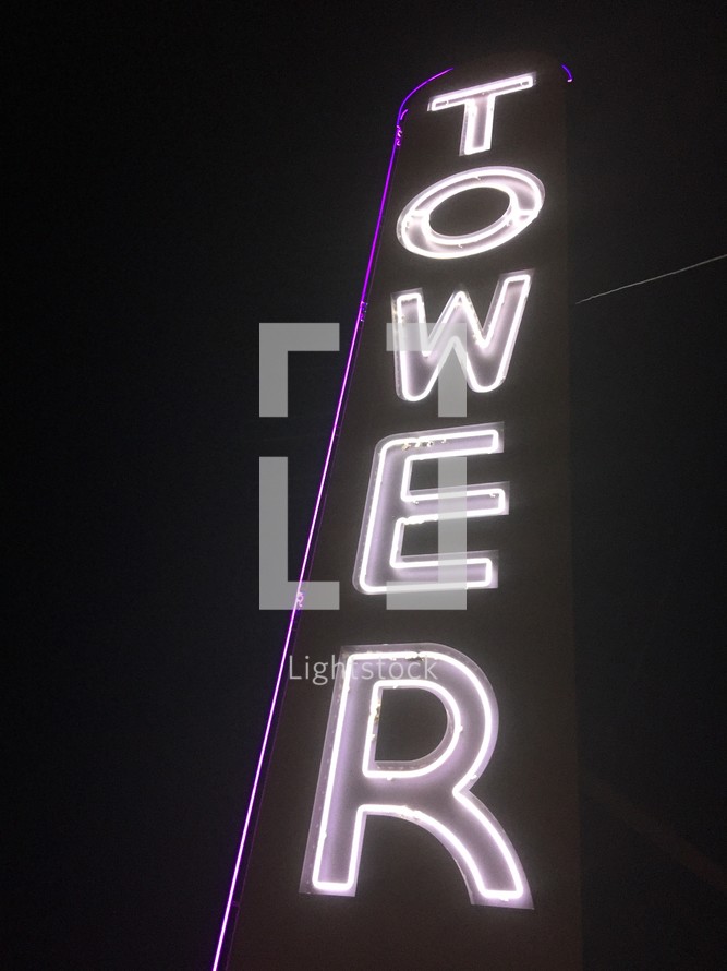A tall neon sign with the word "Tower."
