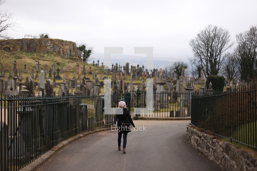 woman walking into a cemetery 