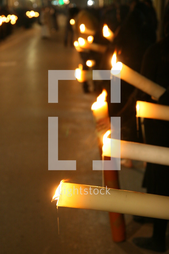 procession of people carrying candles 