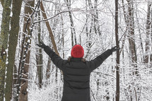 woman with outstretched raised arms standing outdoors in winter 