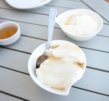 Greek yogurt with honey in a pot on wooden table