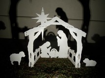 Wooden, outdoor nativity scene casting shadows