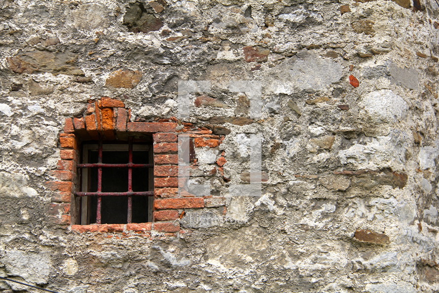 barred window on an old wall 