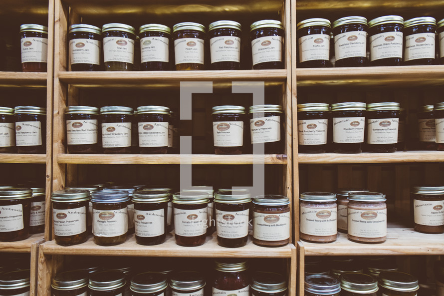 mason jars of preserves on a cupboard shelf 
