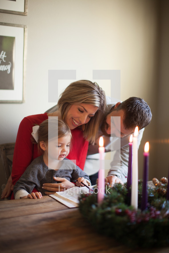 family reading a Bible near an Advent wreath 