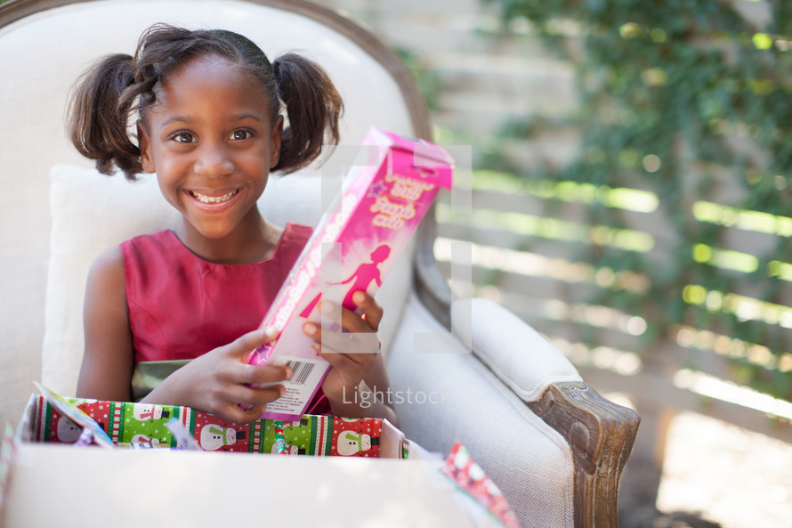 a girl child opening a Christmas gift 