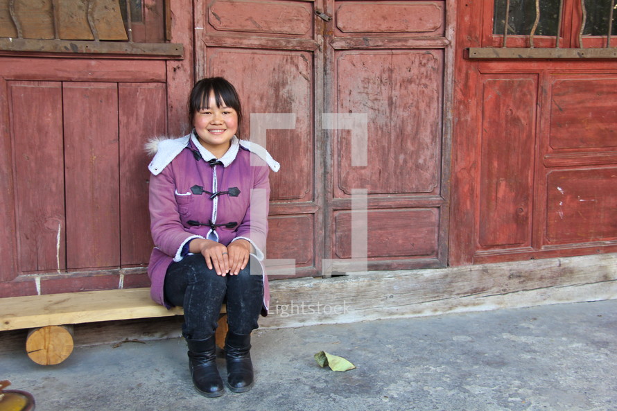 Smiling Chinese woman sitting on a bench in a 'Siheyuan' courtyard residence {Also try search for 'Ethnic Faces'} 