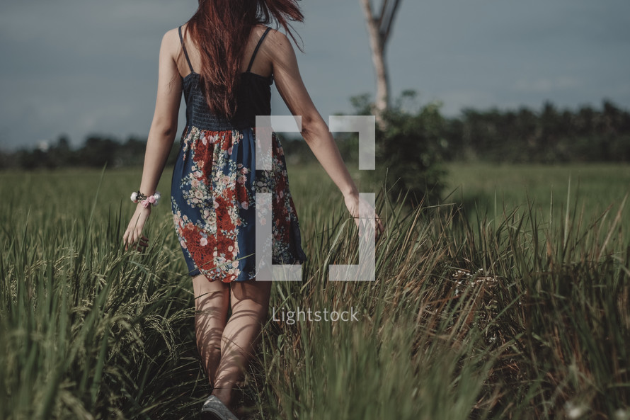 teen girl walking through a field 