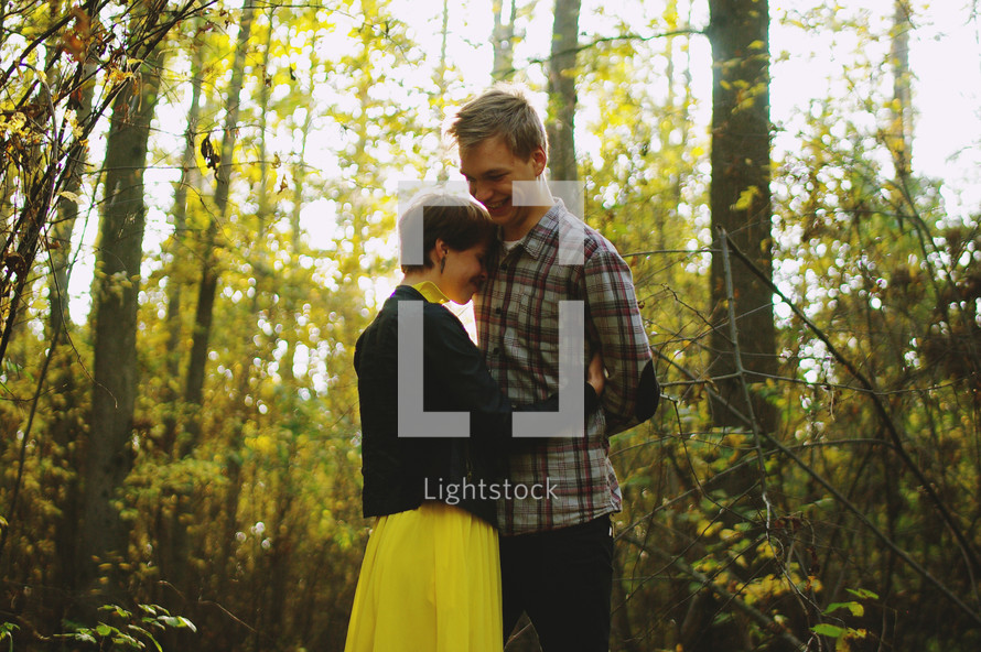 a couple hugging in a fall forest 