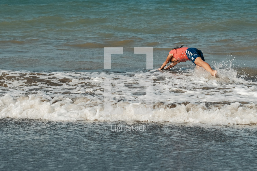 a girl diving into the ocean 