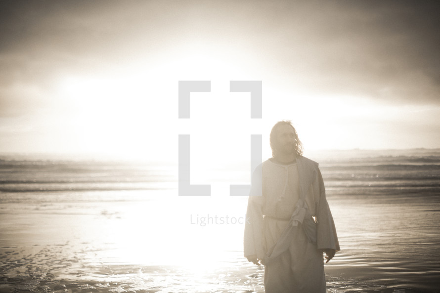 Jesus standing on a shore in bright sunlight 