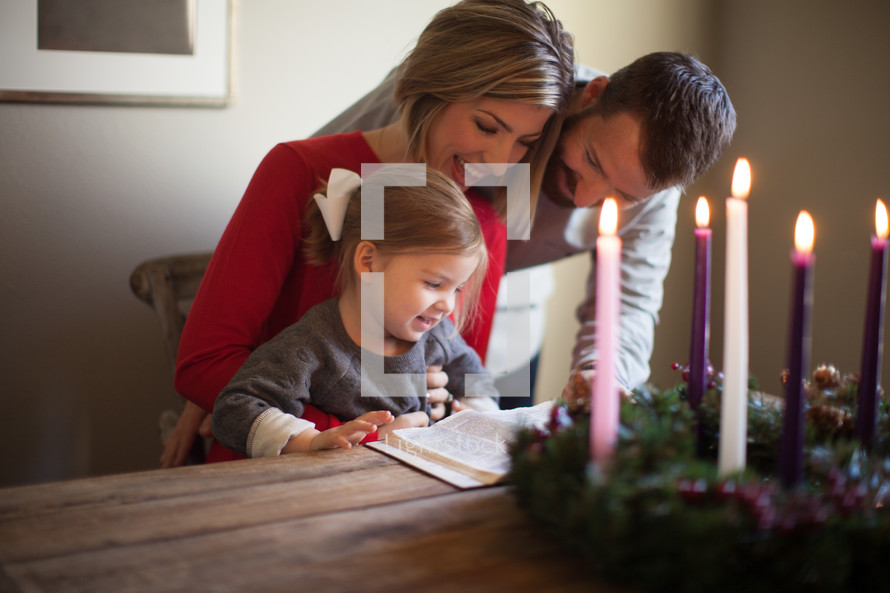 a family reading a Bible near an Advent wreath 