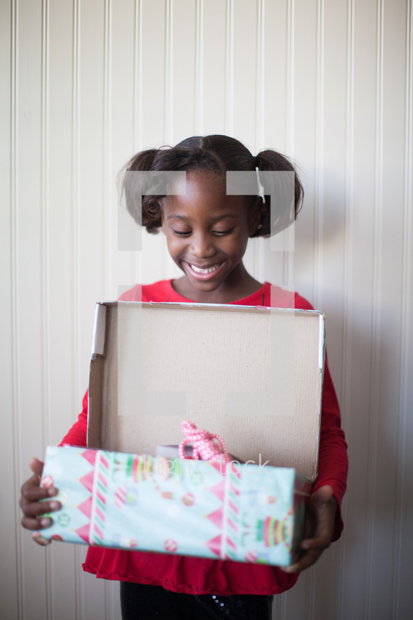 a girl child opening a Christmas present 
