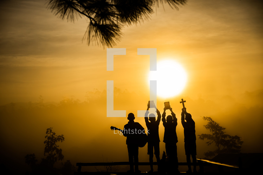 silhouettes of four Christian young men at sunset 