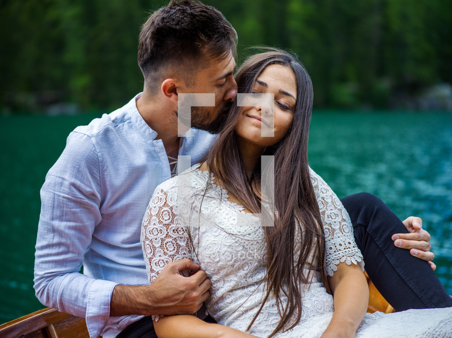 a couple cuddling on a rowboat 