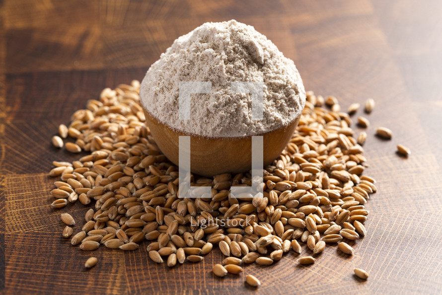 Bowl of flour and Spelt Grain on a Wooden Butchers Block