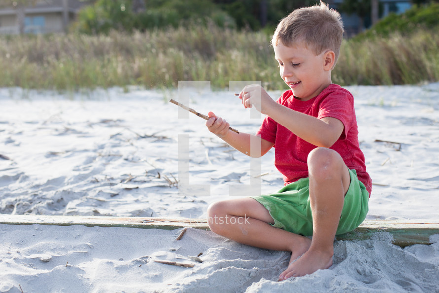child sitting in the sand on a beach 