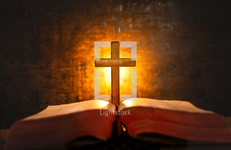 glowing cross in front of an open Bible 