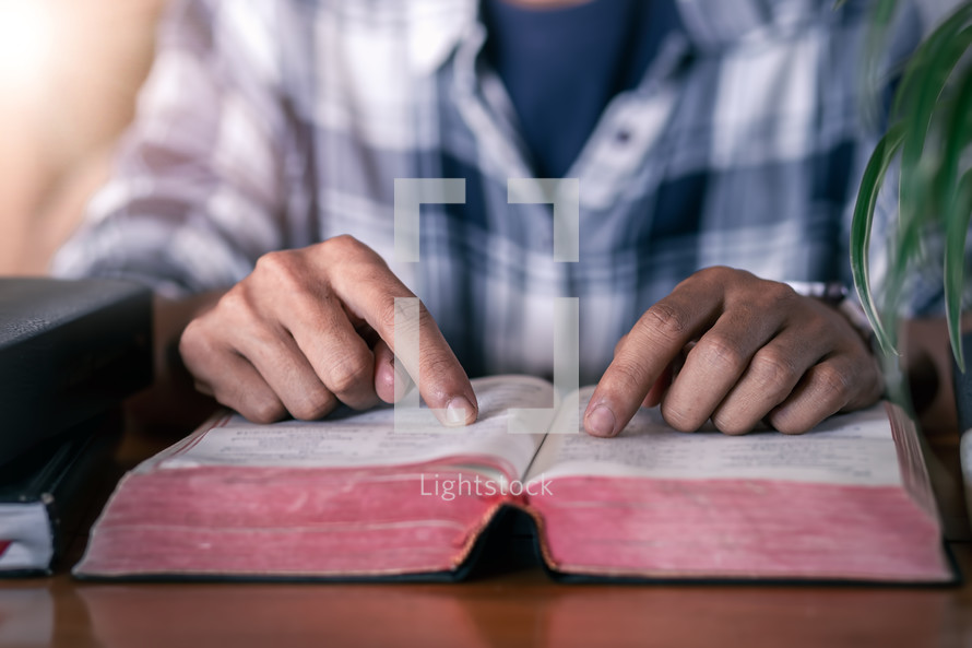 a man sitting at a desk reading a Bible 