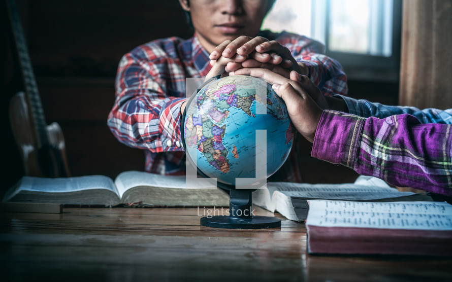 hands on a globe during a small group Bible study 