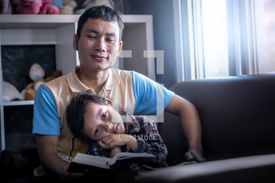 a father reading a Bible to his daughter 