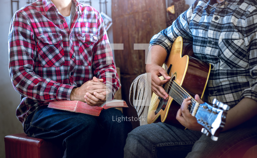 Two young christian share bible and worship music to worship God