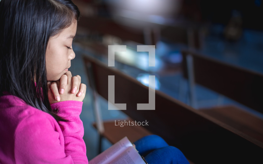 praying child alone in a church 