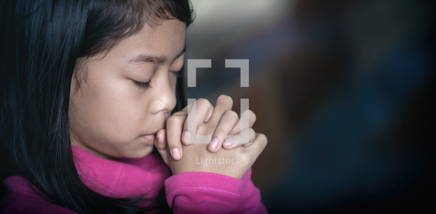 a little girl with praying hands 