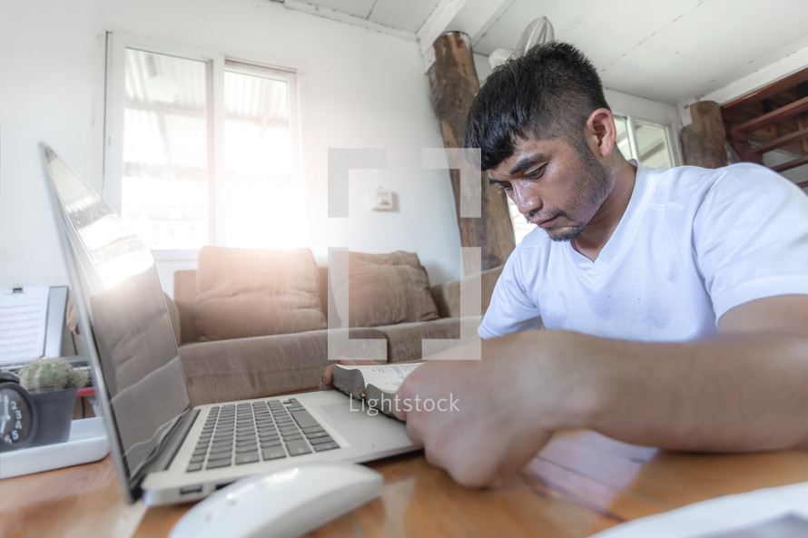 Man praying with computer laptop, Online church in home, Home church during quarantine coronavirus Covid-19, Religion