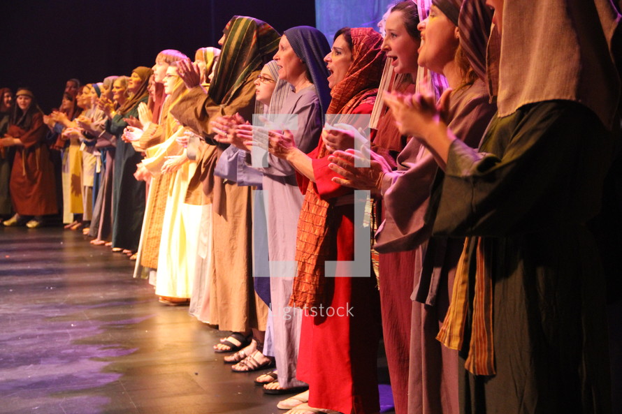 performers dressed as shepherds singing on stage
