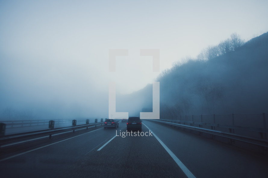 cars driving on a foggy highway 