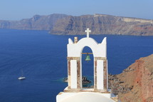 Bell tower on a cliff overlooking the ocean.