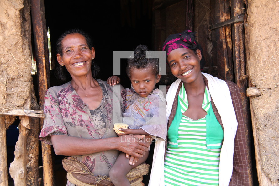 A mother and children in a clay and stick hut in rural Ethiopia.