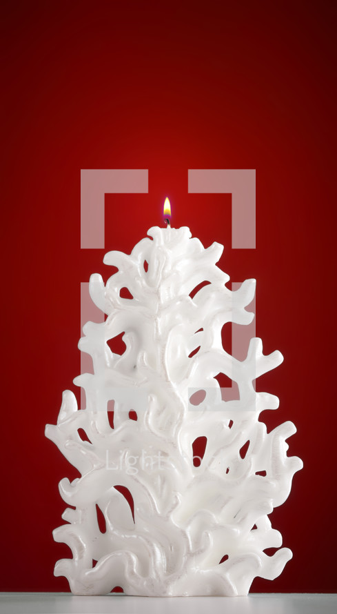 Christmas candle shaped like a Christmas tree on red background