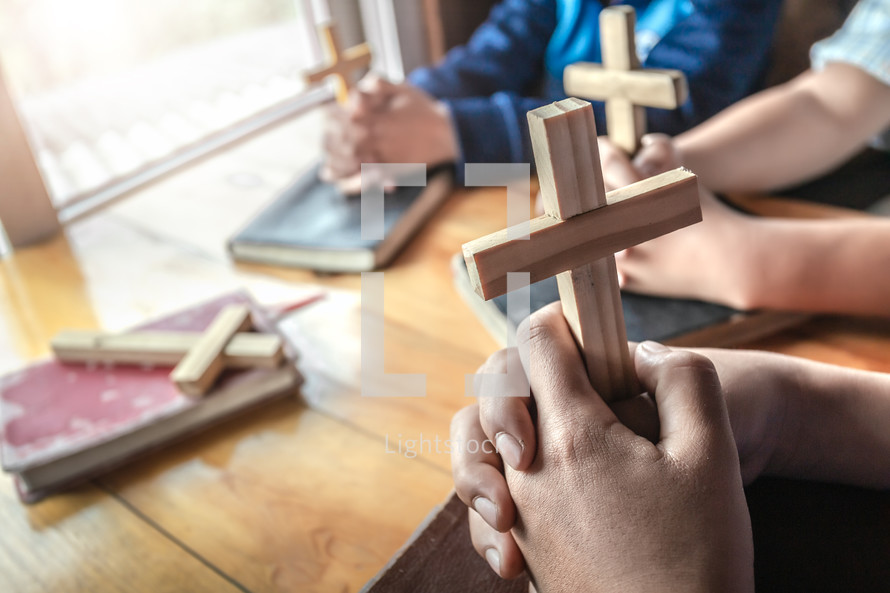 small group Bible study holding wooden crosses 