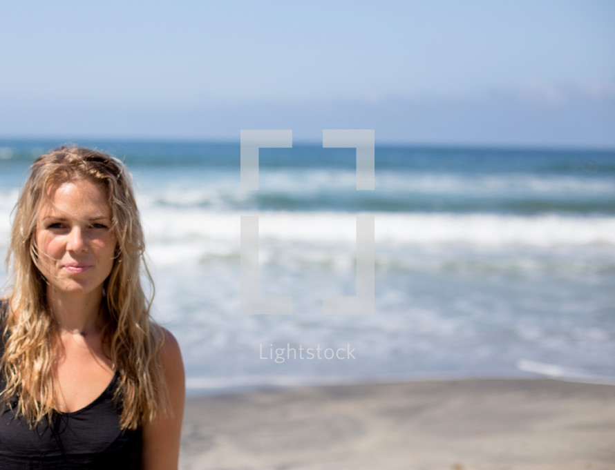 head shot of a woman standing on a beach 