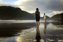 A woman standing on a beach and Jesus looking back at her 