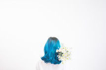 a woman with blue hair holding camomile flowers 