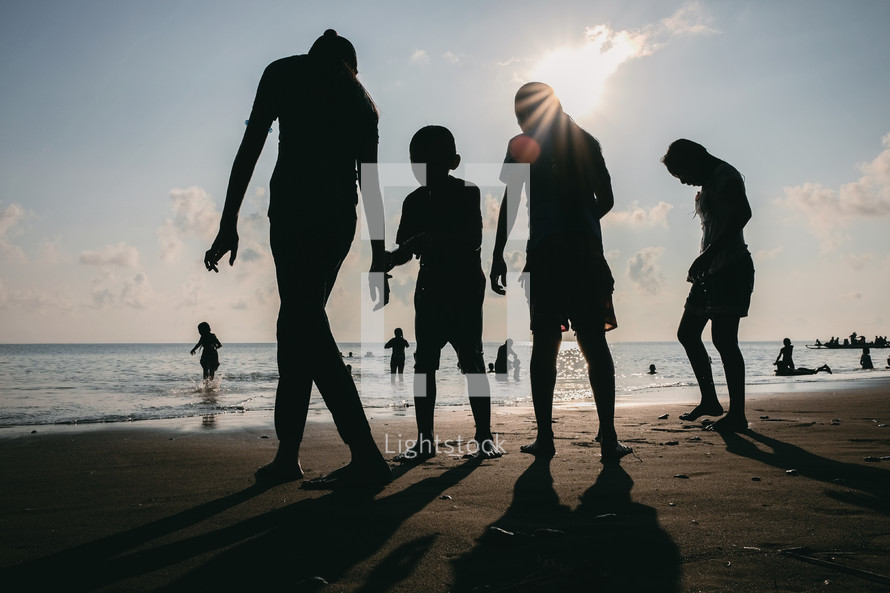 silhouettes of a family on a beach 