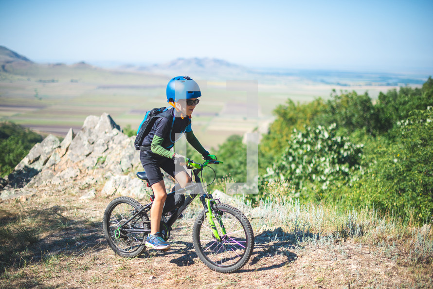 a boy child on a mountain bike exploring the outdoors 