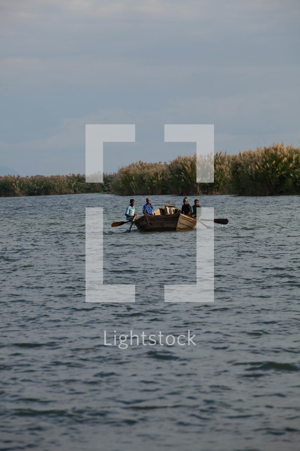 People on a boat in a river in Malawi, Africa. 