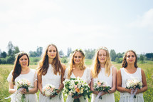 bride and bridesmaids standing outdoors 