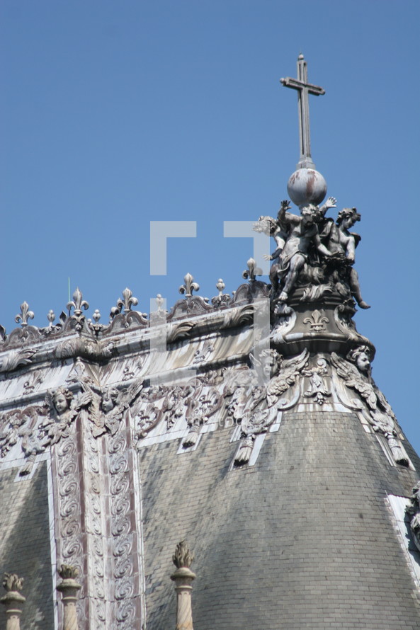 cross on an ornate rooftop
