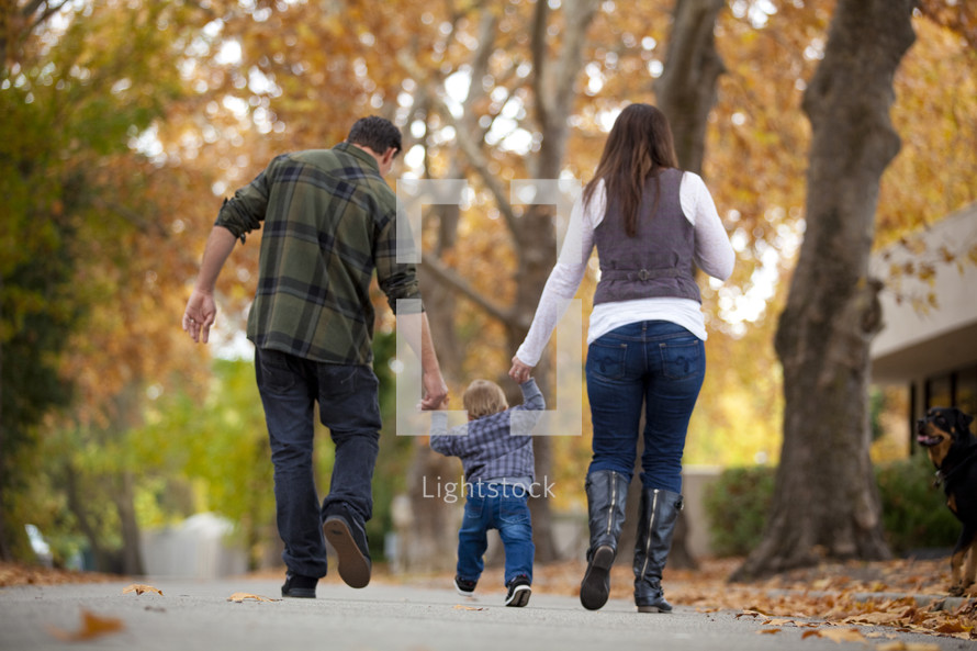 Mother and father walking outdoors with toddler